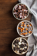 Sweet breakfast cereals in bowl on kitchen table. Top view.