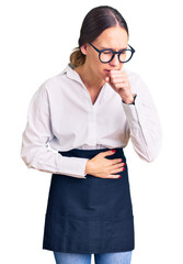 Beautiful brunette young woman wearing professional waitress apron feeling unwell and coughing as symptom for cold or bronchitis. health care concept.