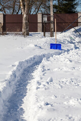 The path on the site is cleared of snow using a snow shovel