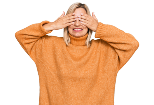 Middle age caucasian woman wearing casual winter sweater covering eyes with hands smiling cheerful and funny. blind concept.