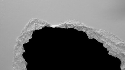 edge of a torn white sheet of paper on a black background, black hole