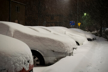 snowstorm  in night, winter in the city. streets and cars covered with snow
