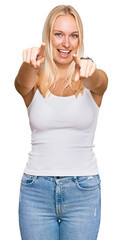 Young blonde girl wearing casual style with sleeveless shirt pointing to you and the camera with fingers, smiling positive and cheerful