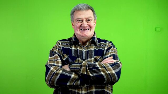 Happy toothless senior man looking at camera and crossing arms over his chest.