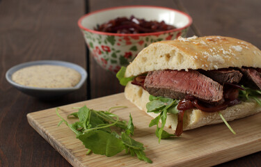 Homemade sandwich of ciabatta with beef, arugula, caramelized onions and mayonnaise.