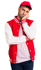 Young hispanic man wearing baseball uniform thinking looking tired and bored with depression problems with crossed arms.