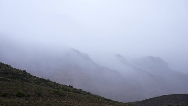 Time lapse of mist and cloud amongst the peaks of the beautiful SwartbergMountains near the tiny hamlet of Klaarstroom at the northern entrance to Meiringspoort. Karoo. Western Cape. South Africa.