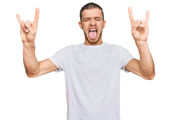 Hispanic young man wearing casual white t shirt shouting with crazy expression doing rock symbol with hands up. music star. heavy concept.