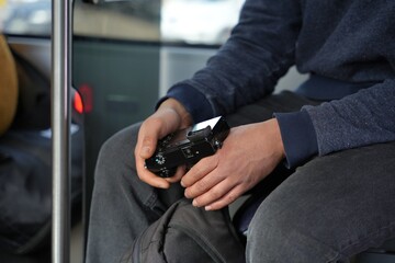 Man holding a digital camera in his hands on a buss