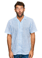 Fototapeta premium Handsome young man with beard wearing casual fresh shirt afraid and shocked with surprise expression, fear and excited face.