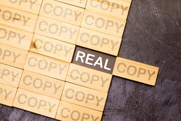 concept REAL and COPY on wooden block