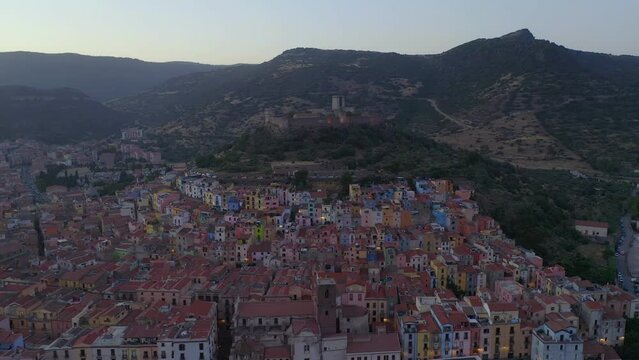 Aerial drone view of Bosa historic city colorful houses with Temo river and historic bridge at sunset in Sardinia, Italy