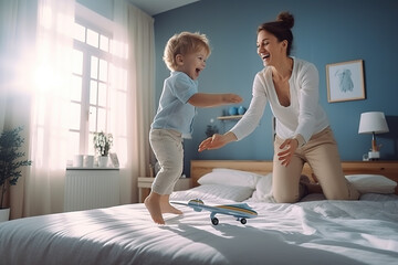 Happy mother playing with her child at home in bed, having fun jumping.