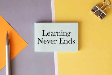 Never stop learning written on a memo stick. Lifelong learning concept.