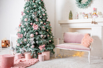 New Year's interior design. Lush Christmas tree with pink and silver ornaments. Pink boxes of gifts and a rug, a velour pink sofa with a fluffy pillow. A fireplace with cute Christmas decorations.