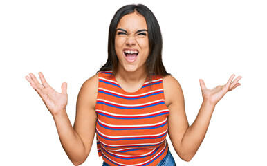 Young brunette woman wearing casual clothes crazy and mad shouting and yelling with aggressive expression and arms raised. frustration concept.