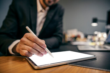 Close up of architect's hand drawing blueprints on tablet.
