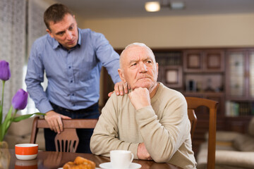 Senior man and his adult son quarreling at home