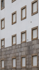 Fototapeta premium Detalhe da fachada de um prédio de 5 andares sem varandas.