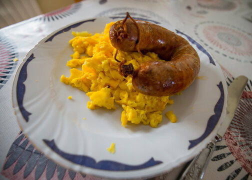 Detalhe da refeição de ovos mexidos com linguiça de porco. Comida tradicional dos fundos da serra, norte de Portugal.