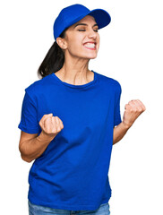 Young hispanic girl wearing delivery courier uniform excited for success with arms raised and eyes closed celebrating victory smiling. winner concept.