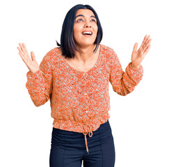 Young beautiful latin woman wearing casual clothes crazy and mad shouting and yelling with...