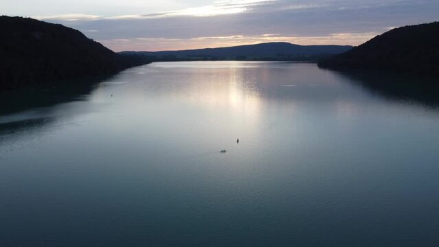 Vue aérienne panoramique d’un lac au coucher de soleil avec paddle, Jura
