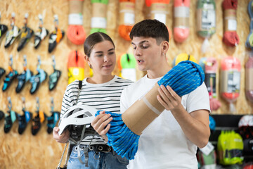 Couple deciding on climbing equipment in sports equipment store