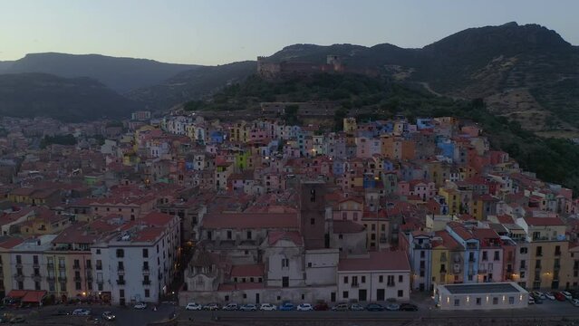 Aerial drone view of Bosa historic city colorful houses with Temo river and historic bridge at sunset in Sardinia, Italy