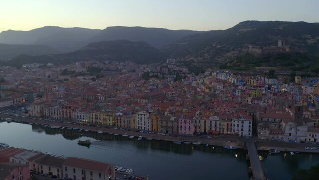 Aerial drone view of Bosa historic city colorful houses with Temo river and historic bridge at sunset in Sardinia, Italy