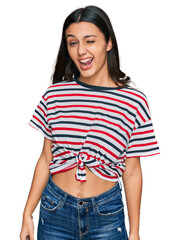 Fototapeta premium Young hispanic girl wearing casual clothes winking looking at the camera with sexy expression, cheerful and happy face.