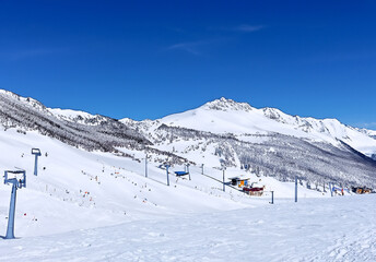 Fototapeta na wymiar 快晴、青空の背景のスキー場の写真　雪山ウィンタースポーツ　レジャー　スノーボード　AI生成画像