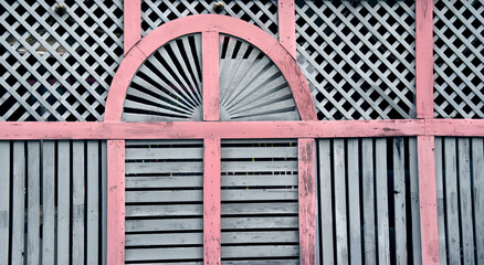 Faded Facade of Lattice Work and Pink Trim