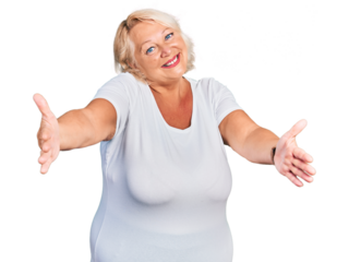 Middle age blonde woman wearing casual white t shirt looking at the camera smiling with open arms for hug. cheerful expression embracing happiness.