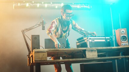 Woman artist mixing records and vinyl for disco tunes, having fun with disc mixing turntables for...