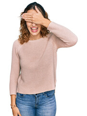 Fototapeta premium Beautiful young caucasian woman wearing casual sweater smiling and laughing with hand on face covering eyes for surprise. blind concept.