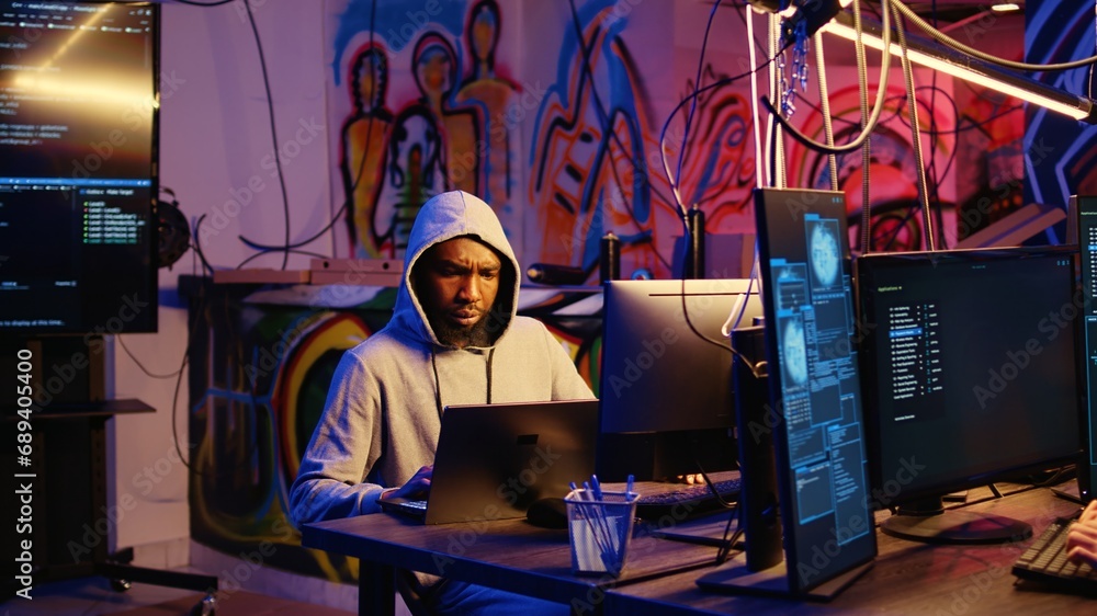 Poster hacker arriving with laptop in hidden base, deploying viruses on unaware victims computers, stealing