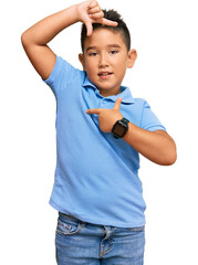 Little boy hispanic kid wearing casual clothes smiling making frame with hands and fingers with happy face. creativity and photography concept.