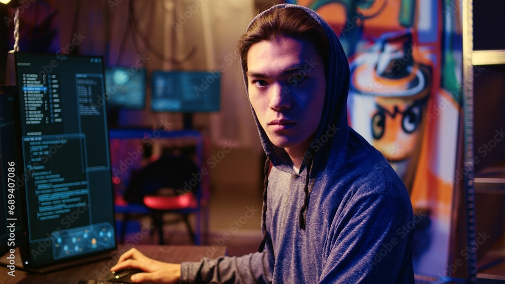 Poster portrait of asian hacker running code in graffiti painted basement, looking to find exploits for sys