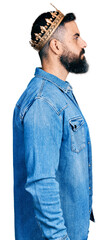 Hispanic man with beard wearing king crown looking to side, relax profile pose with natural face...