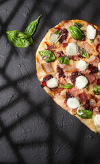Delicious and crispy heart-shaped red fruit pizza with basil
