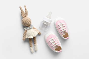 Knitted toy, shoes and baby bottle on white background