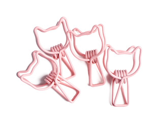 Pink binder clips in shape of cats on white background