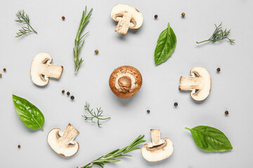 Set of raw champignon mushrooms with spices on grey background