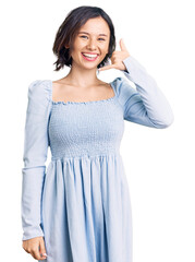 Young beautiful girl wearing casual clothes smiling doing phone gesture with hand and fingers like talking on the telephone. communicating concepts.