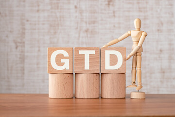 There is wood cube with the word GTD. It is an abbreviation for Getting Things Done as eye-catching...
