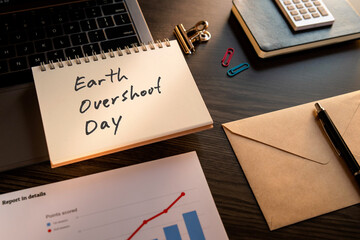 There is notebook with the word Earth Over Shoot Day. It is as an eye-catching image.