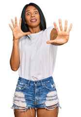 Young african american woman wearing casual clothes afraid and terrified with fear expression stop...