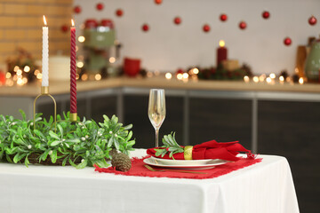 Table setting with Christmas mistletoe wreath in kitchen, closeup