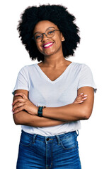 Young african american woman wearing casual white t shirt happy face smiling with crossed arms looking at the camera. positive person.